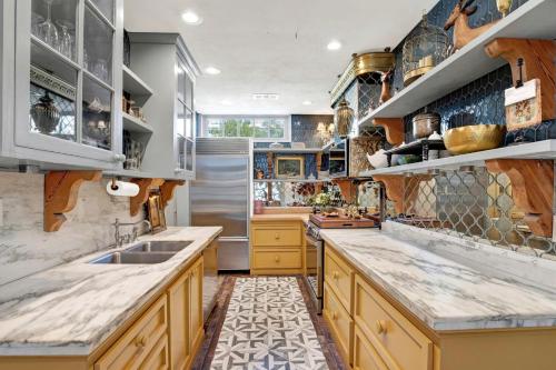 a kitchen with yellow cabinets and marble counter tops at The Stables in Savannah
