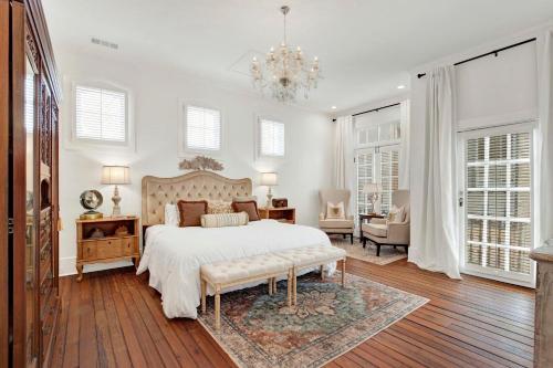 a white bedroom with a bed and a chandelier at The Stables in Savannah