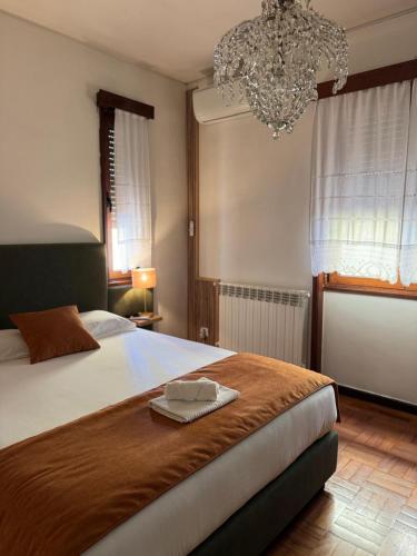 a bedroom with a large bed and a chandelier at Casa do Ribeirinho in Amarante