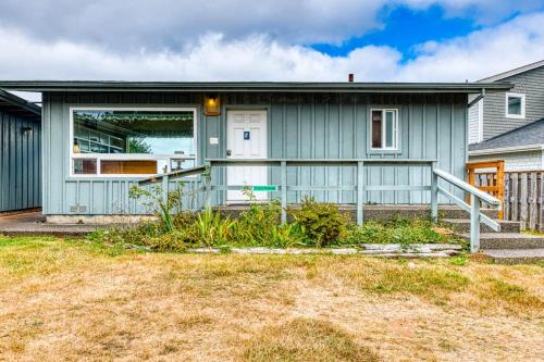 a blue house with a white door at Inviting dog-friendly studio with unobstructed ocean views in Bandon