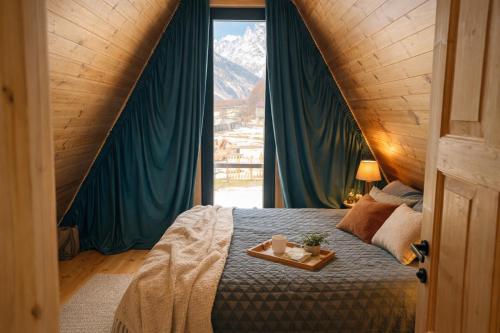 a bedroom with a bed with a tray on it at Mestia Inn Chalet in Mestia