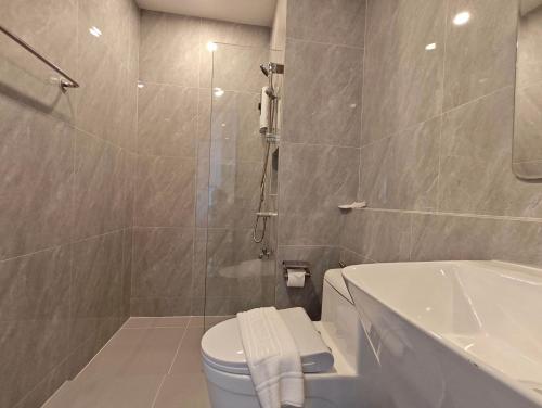a bathroom with a shower and a toilet and a tub at Prajan Residence in Buriram