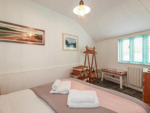a bedroom with a bed with two towels on it at Smugglers Cottage in Tintagel