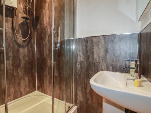 a bathroom with a shower and a sink and a tub at Smugglers Cottage in Tintagel