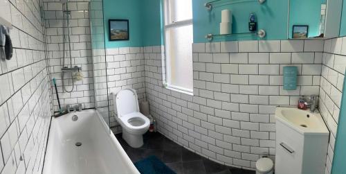 a bathroom with a tub and a toilet and a sink at The Old Bakery in Sandwich