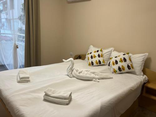 a bed with towels and a stuffed animal on it at Topalov in Sandanski