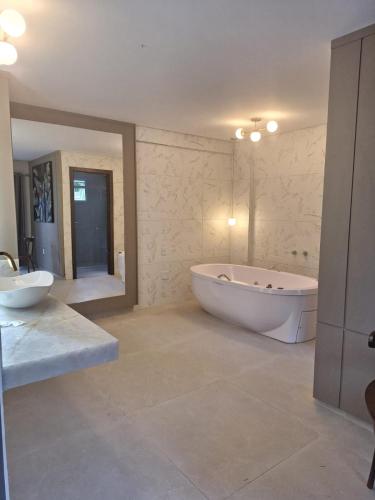 a large bathroom with a tub and two sinks at Santa Mônica Palace Hotel in Corumbá