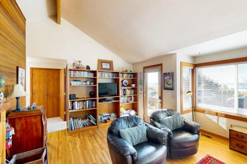 a living room with two chairs and a television at Charming oceanfront cottage with WiFi & easy beach access in Cannon Beach