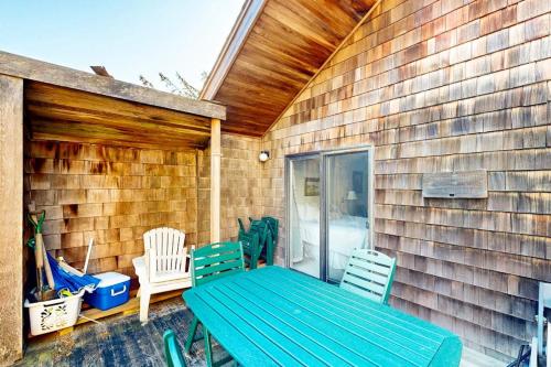 a green table and chairs on a patio at Charming oceanfront cottage with WiFi & easy beach access in Cannon Beach
