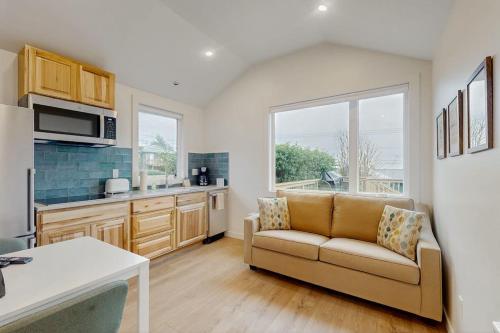 a living room with a couch and a kitchen at Dog-friendly comfy cabin only two blocks from the beach in Cannon Beach
