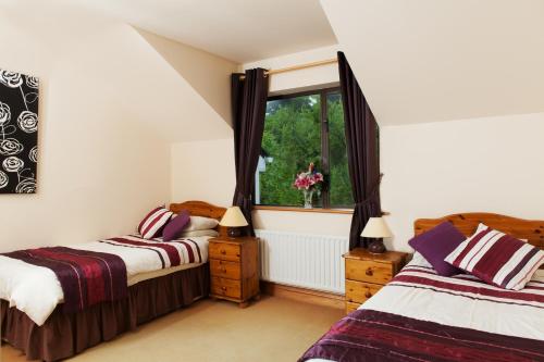 a bedroom with two beds and a window at Benbaun House in Clifden