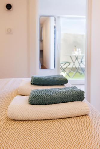 three pillows are stacked on top of a bed at Apt Le Frene in Tourrettes-sur-Loup