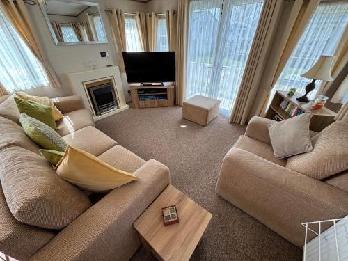 a living room with two couches and a television at L60, Two bedroom caravan - California Cliffs, Parkdean Resort, Scratby - Sleeps 6, bed linen, towels plus Wi-Fi included - Sorry no pets in Great Yarmouth