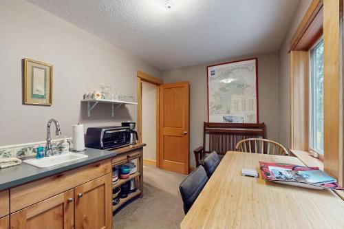 a kitchen with a table and a sink and a microwave at Charming riverfront apartment with kitchenette grill & central AC in Welches