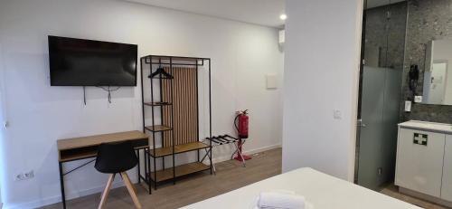 a living room with a television on a wall at Cais 75 Studios & Suites in Aveiro
