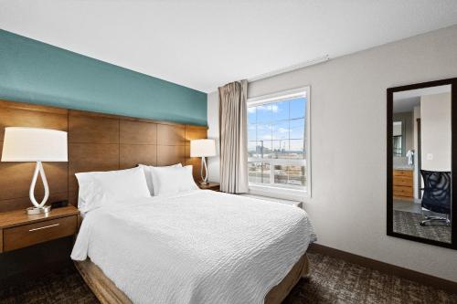 a bedroom with a large bed and a window at Staybridge Suites - Calgary Airport by IHG in Calgary