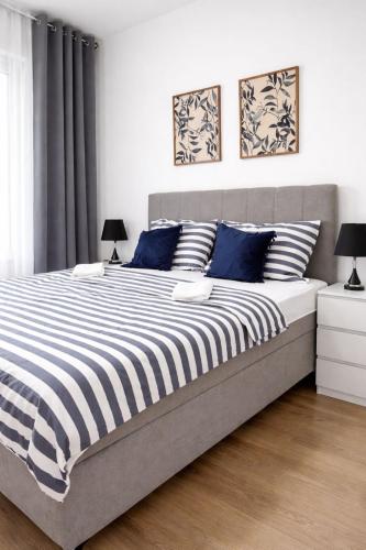 ein Schlafzimmer mit einem großen Bett und blauen Kissen in der Unterkunft NeraHome in Banja Luka