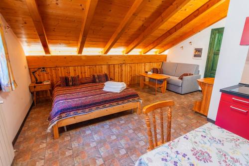 a bedroom with a bed and a couch in a room at Chalet Presanella in Temù