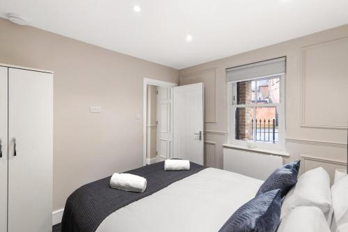 a bedroom with a bed with two towels on it at Spacious 2-Bed Home in Chipping Barnet in Barnet