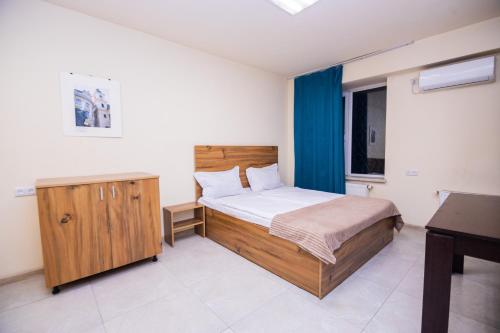 a bedroom with a wooden bed and a desk at The Best Hostel in Yerevan