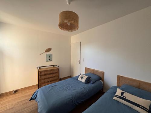 a bedroom with two beds and a dresser at Le Clos des Embruns in Chassiron