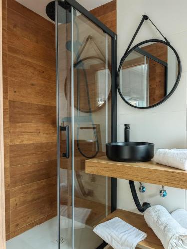 a glass shower stall with a sink and a mirror at Hostal Casa Miguel Marbella in Marbella