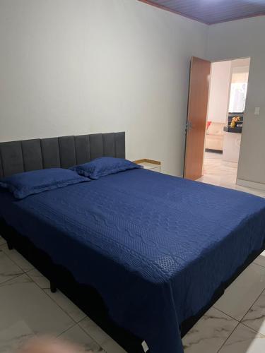 a bedroom with a bed with a blue comforter at Casa com área de lazer tranquila e espaçosa! in Campo Grande
