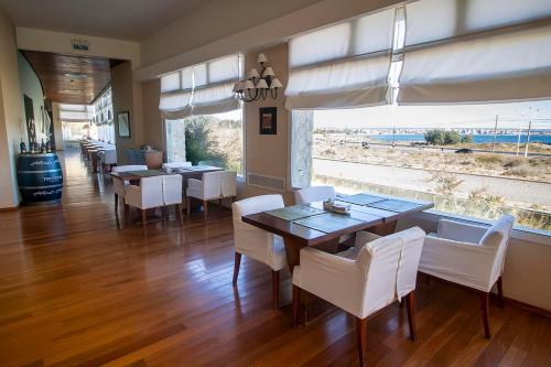 a dining room with white chairs and a dining table at Hotel Territorio in Puerto Madryn