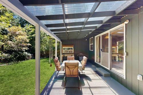 a patio with a table and chairs on a house at Spacious home with full kitchen wifi private backyard & grill in Welches