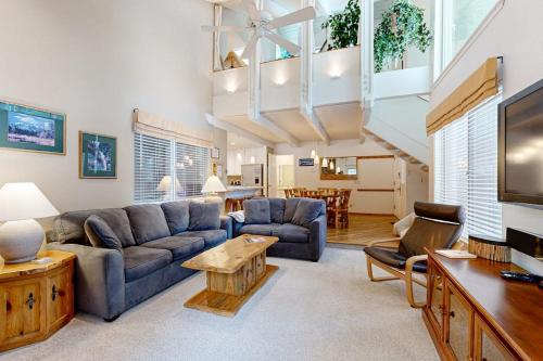 a living room with a couch and a table at Comfortable condo with shared pool SHARC passes trails and more in Sunriver