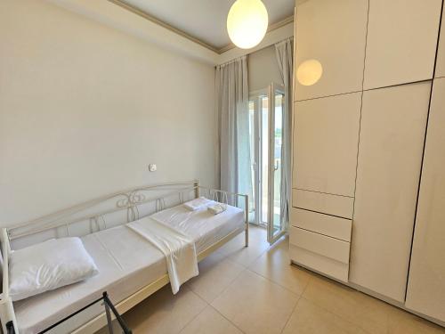 a white bedroom with a bed and a closet at GREY LUXURY HOUSE in Ipsos