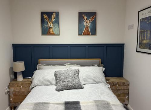 a bedroom with a bed with two pictures on the wall at Clare Escape - Modern apartment Ballycastle town centre & walk to beach in Ballycastle