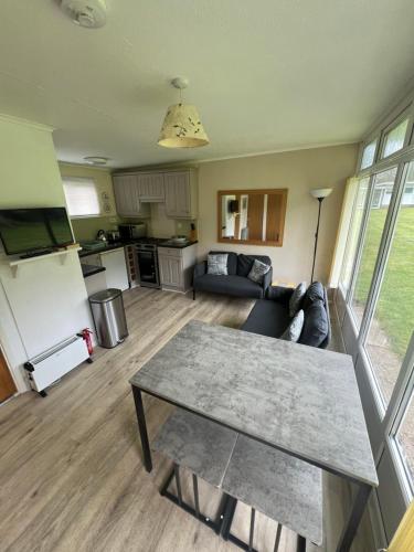 a living room with a table and a couch at Cromer Coastal Retreat Kings Chalet Park in Cromer