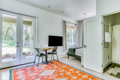 a bedroom with a bed and a desk and a television at Dog-friendly studio with river view patio grill & shared W&D in Stevenson