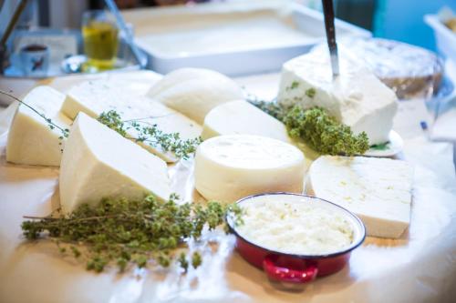 a bunch of cheese on a table with a bowl of dip at Tourist Boutique Hotel in Argostoli