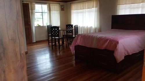 a bedroom with a bed and a table and chairs at El Corral in Cuenca