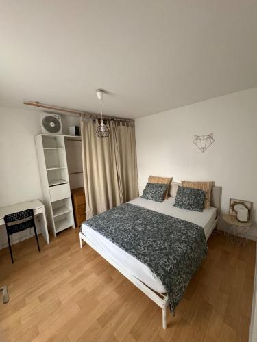 a bedroom with a bed and a desk in it at Appartement T2 à Chelles - Paris, CDG & Disneyland à proximité, parking privé in Chelles