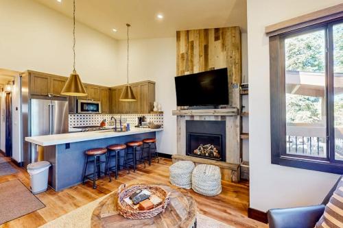 a kitchen with a bar and a fireplace at Ski and Ski Out Designer Condo With a View in Kingswood Estates