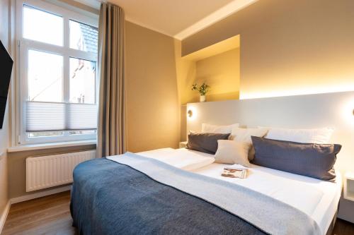 a bedroom with a large bed with a window at Woge2 Appartement 1 in Borkum