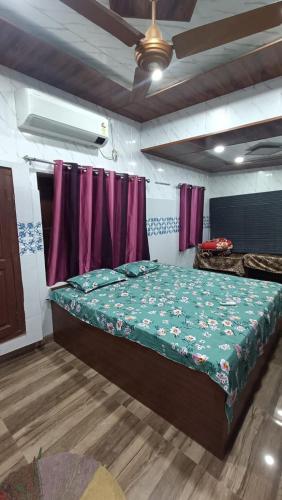 a bedroom with a bed and a ceiling fan at Sakchi Gopal Ashram in Vrindāvan