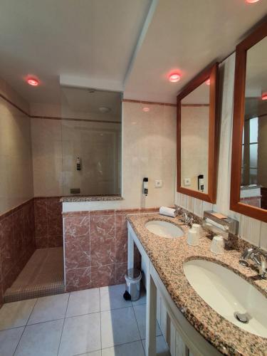 a bathroom with two sinks and a shower at Manoir Du Cunningham in Saint Malo