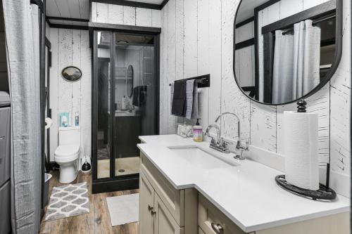 a bathroom with a sink and a toilet and a mirror at Hoofbeat Haven in Sturgis