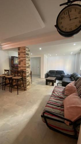 a living room with a couch and a clock on the wall at SunWave Chott Meriem in Sousse
