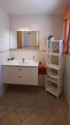 a bathroom with a sink and a mirror and a shelf at Casa Panorama in La Pared