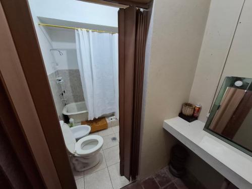 a bathroom with a toilet and a sink and a mirror at Casa en El Rodeo in El Rodeo