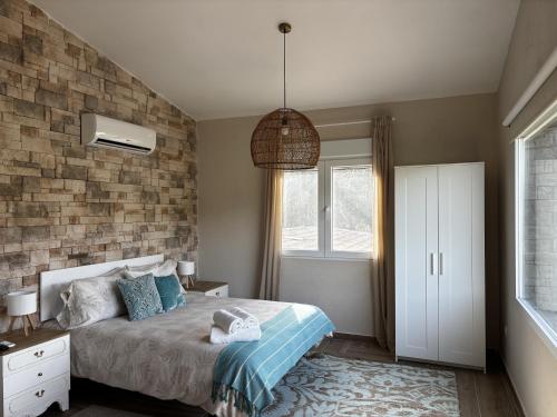 a bedroom with a bed and a brick wall at Finca Avellaneda in Navahonda