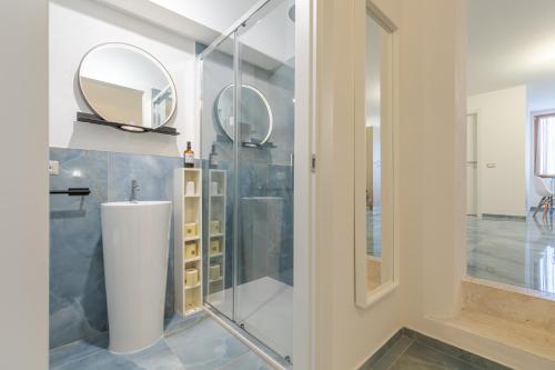 a bathroom with a shower with a sink and a mirror at L'Acqua e la Pietra in Rapolano Terme