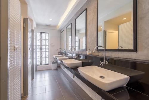 バンコクにあるX9ホステルの洗面台3つと鏡2つ付きのバスルーム