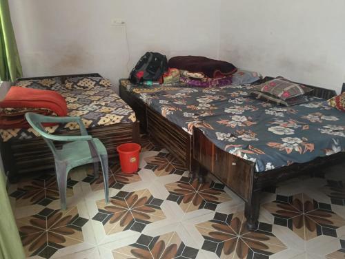 a room with two twin beds and a chair at Hotel Himalayan dews in Ukhimath