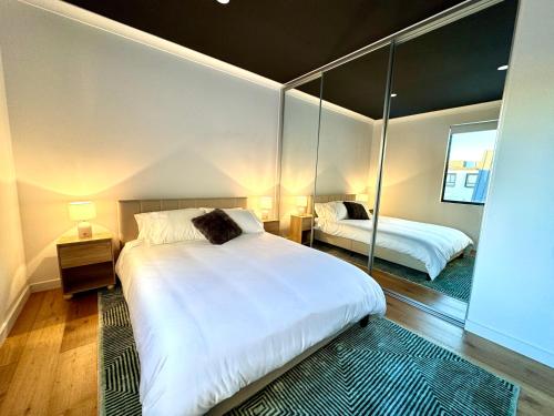 a bedroom with two beds with mirrors in it at Stylish Industrial City Retreat in Bowden